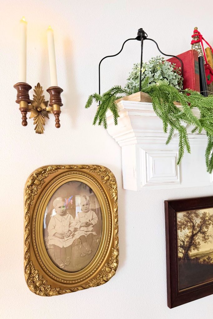 Antique convex gold oval frame with vintage photo of twin boys, displayed on a white wall beside other framed artwork in a cozy farmhouse living room.