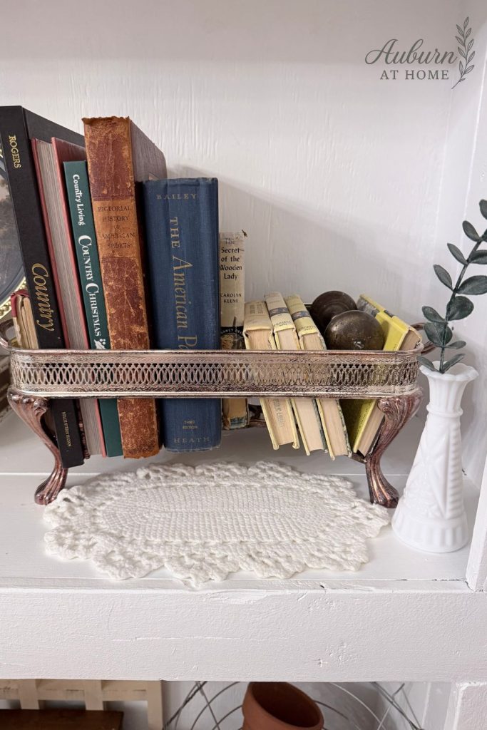 Layered vintage books in metal serving tray