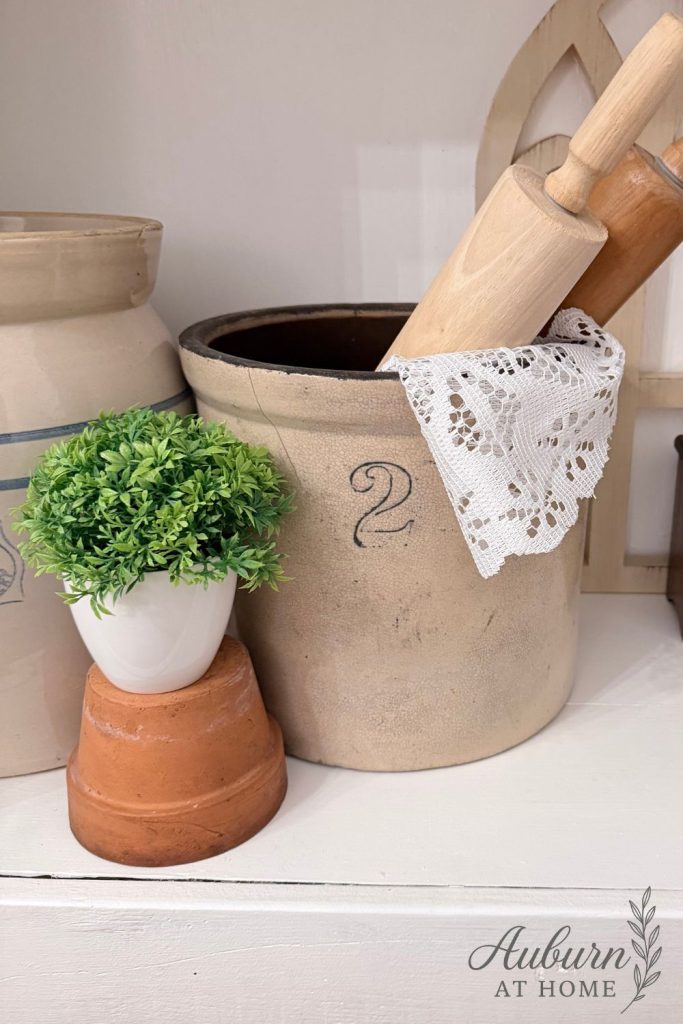 Farmhouse shelf with vintage crocks and terra cotta pots