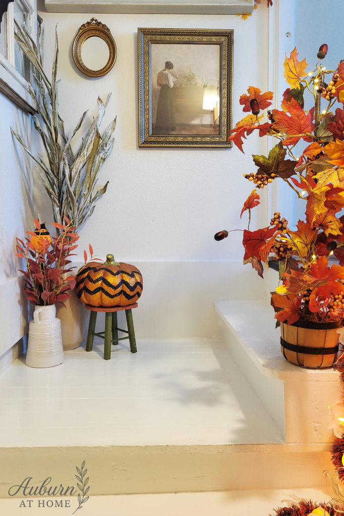 Fall decor on stairwell. Pumpkins, fall floral & vintage light up jack o lantern