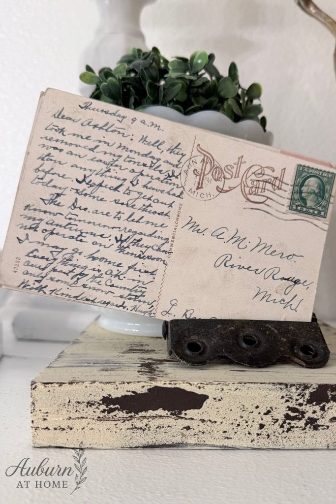 Farmhouse shelf with vintage postcard and salvaged door hinge