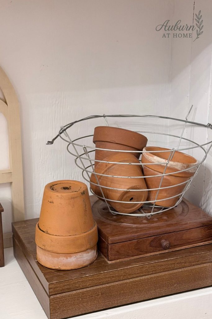 Farmhouse shelf with vintage crocks and terra cotta pots