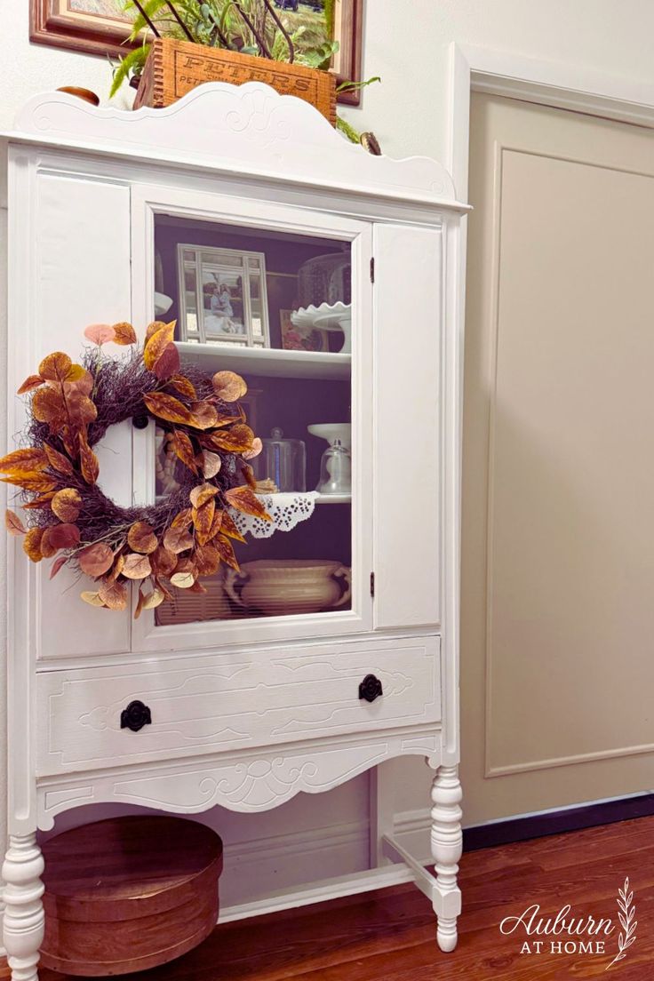 White hutch decorated for Fall with Autumn wreath