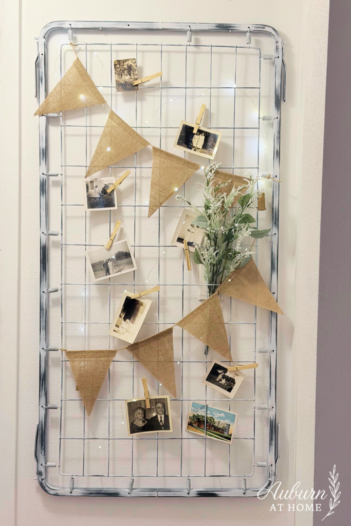 DIY wall decor made from a vintage crib spring with burlap bunting and black-and-white photos