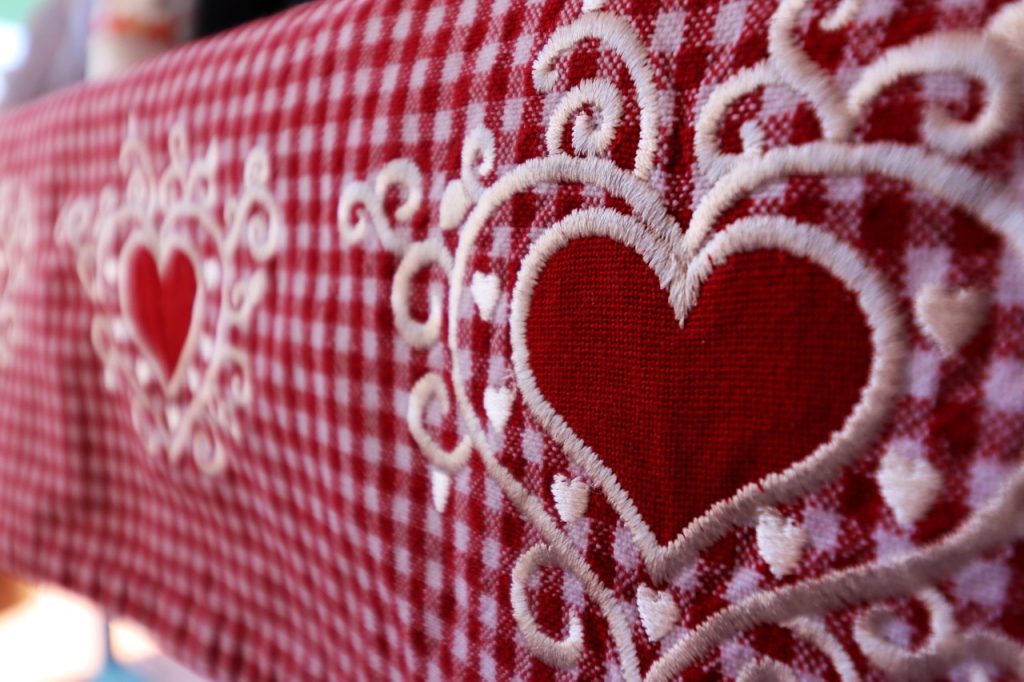 Vintage embroidered heart detail on red gingham fabric for classic Valentine’s decor inspiration