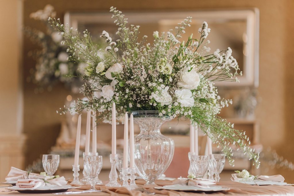 Soft neutral Valentine’s table styled with white florals, baby’s breath, and vintage glassware
