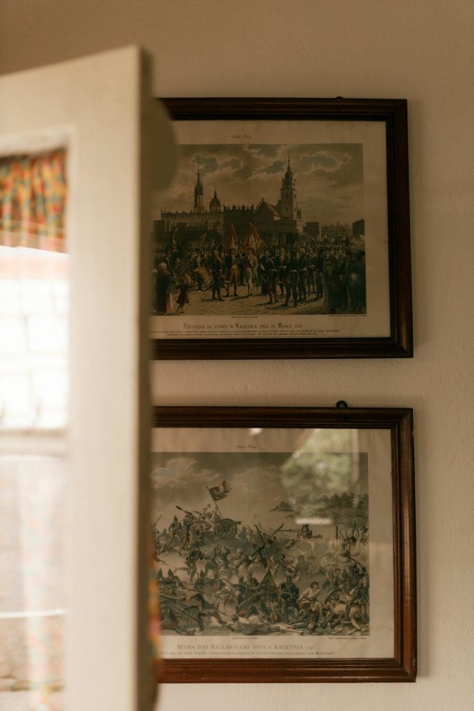 Stacked vintage framed prints hung on a neutral wall, adding layered character and a collected cottage feel to the space.